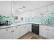Modern kitchen featuring white cabinets, granite countertops, and stylish teal hexagon backsplash at 1255 N Gulfstream Ave # 204, Sarasota, FL 34236