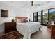 Bright main bedroom with a floral comforter, wood floors, and a private balcony at 1255 N Gulfstream Ave # 204, Sarasota, FL 34236