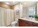 The bathroom has a well-lit vanity, a large mirror, and a toilet with a shower and tub combo at 130 Riviera Dunes Way # 1104, Palmetto, FL 34221