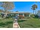 Light blue house with walkway, green lawn, and palm trees at 1312 Stafford Ln # 1427, Sarasota, FL 34232