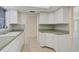 L-shaped kitchen with white cabinets and green countertops at 1312 Stafford Ln # 1427, Sarasota, FL 34232