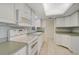 Kitchen with white cabinets, tile backsplash, and modern appliances at 1312 Stafford Ln # 1427, Sarasota, FL 34232