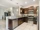 Modern kitchen featuring dark cabinetry, granite counters, and stainless steel appliances at 14339 Easy Goer St, Ruskin, FL 33573