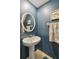 Stylish powder room with pedestal sink, decorative towels, and coastal-themed art at 14339 Easy Goer St, Ruskin, FL 33573