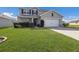 Two-story house with gray siding, landscaping, and a two-car garage at 15404 Trinity Fall Way, Bradenton, FL 34212