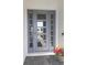Modern gray front door with glass panels and sidelights at 16415 Isola Pl, Bradenton, FL 34211