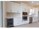 Modern kitchen with white cabinets, stainless steel appliances and wine cooler at 16415 Isola Pl, Bradenton, FL 34211