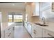 Open concept kitchen with white cabinets, stainless steel appliances and backyard access at 16415 Isola Pl, Bradenton, FL 34211