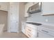 Modern kitchen features gas cooktop, stainless steel range hood, and white cabinets at 16415 Isola Pl, Bradenton, FL 34211