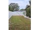 Private backyard with a large grassy area and a white vinyl fence at 2430 Sunnyside Ln, Sarasota, FL 34239