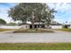 Ranch style home with mature landscaping and a large driveway at 2430 Sunnyside Ln, Sarasota, FL 34239