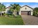 Single-story home with a brick paved driveway and lush landscaping at 26768 Weiskopf Dr, Englewood, FL 34223