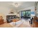 Living room with leather couch, screened patio access and TV at 277 Sherwood Dr # 277D, Bradenton, FL 34210