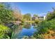Serene view of a pond with lush landscaping and a reflection of the building at 277 Sherwood Dr # 277D, Bradenton, FL 34210