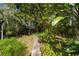 Stone path winds through lush, tropical landscaping in the backyard at 327 Hernando Ave, Sarasota, FL 34243