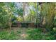 Overgrown backyard with a low concrete wall at 327 Hernando Ave, Sarasota, FL 34243