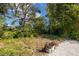 Lush backyard with mature trees and a gravel pathway at 327 Hernando Ave, Sarasota, FL 34243