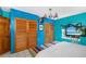 Bedroom with teal walls, wood closet doors, and a large bed at 327 Hernando Ave, Sarasota, FL 34243