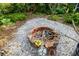 Brick fire pit with decorative accents in a gravel backyard at 327 Hernando Ave, Sarasota, FL 34243