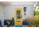 Inviting yellow door entrance with blue tile and landscaping at 327 Hernando Ave, Sarasota, FL 34243