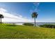 Scenic waterfront property with grassy lawn and palm trees at 327 Hernando Ave, Sarasota, FL 34243