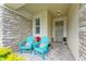 Inviting front porch with stone accents and colorful Adirondack chairs at 3640 Tin Cup Blvd, Sarasota, FL 34232