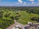 Aerial view showcasing the golf course, clubhouse, and surrounding landscape at 3704 Wild Blossom Pl, Parrish, FL 34219