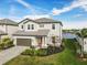 Two-story house with gray roof and orange door, near water at 3704 Wild Blossom Pl, Parrish, FL 34219