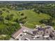 Aerial view of lush green golf course and clubhouse at 3704 Wild Blossom Pl, Parrish, FL 34219