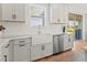 Modern kitchen features white cabinets, a farmhouse sink, and quartz countertops at 3704 Wild Blossom Pl, Parrish, FL 34219