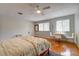Cozy bedroom with hardwood floors, a ceiling fan, and a small sitting area at 3712 Sandspur Ln, Nokomis, FL 34275