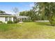 Large grassy backyard with screened enclosure and a white picket fence at 4810 Bay Shore Rd, Sarasota, FL 34234