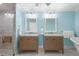 Bathroom with light blue walls, double vanity, and a soaking tub at 4810 Bay Shore Rd, Sarasota, FL 34234