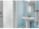 Small half bathroom with pedestal sink and light blue walls at 4810 Bay Shore Rd, Sarasota, FL 34234