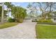 Attractive home with paver driveway, lush landscaping, and mature trees at 4810 Bay Shore Rd, Sarasota, FL 34234