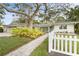 Charming ranch house with mature landscaping and a white picket fence at 4810 Bay Shore Rd, Sarasota, FL 34234