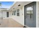 Side entrance with gray door, tiled flooring and landscaping at 4810 Bay Shore Rd, Sarasota, FL 34234