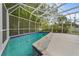 Screened-in pool with surrounding patio and lush landscaping at 4810 Bay Shore Rd, Sarasota, FL 34234
