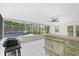 Enjoy this screened patio with pool view, tile flooring, ceiling fan and outdoor kitchen at 4810 Bay Shore Rd, Sarasota, FL 34234