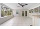 Bright screened patio features tile floors and a ceiling fan at 4810 Bay Shore Rd, Sarasota, FL 34234