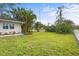 Landscaped side yard with a white picket fence and mature trees at 4810 Bay Shore Rd, Sarasota, FL 34234