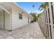 Landscaped side yard with paver patio and wood fence at 4810 Bay Shore Rd, Sarasota, FL 34234