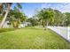 Landscaped side yard with a white picket fence and mature trees at 4810 Bay Shore Rd, Sarasota, FL 34234