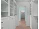 Bright white walk-in closet with glass-front cabinets and drawers at 4810 Bay Shore Rd, Sarasota, FL 34234