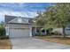 Two-story house with a gray exterior, two-car garage, and a tree in the front yard at 4914 60Th E Dr, Bradenton, FL 34203