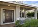 Front porch with dark brown door, white railing, ceiling fan, and potted plants at 4914 60Th E Dr, Bradenton, FL 34203