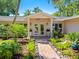 Front entry with double doors, a covered porch, and lush landscaping at 5140 Windward Ave, Sarasota, FL 34242