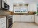 Modern kitchen with white cabinets, granite countertops, and stainless steel appliances at 5140 Windward Ave, Sarasota, FL 34242