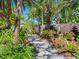 Landscaped walkway with tropical plants, rock accents, and a tiered fountain at 5140 Windward Ave, Sarasota, FL 34242
