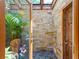 Spa-like outdoor shower with stone walls and tropical plants at 5140 Windward Ave, Sarasota, FL 34242
